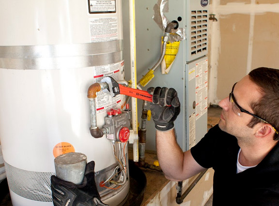 Jack is a wrench to tighten a valve on a water heater repair in Palmetto Bay