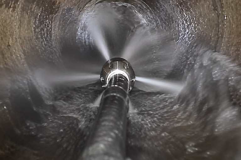 a hydro jetting in action removing debris from the sewer walls